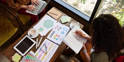 Female designers working on logo for the website, view from the top